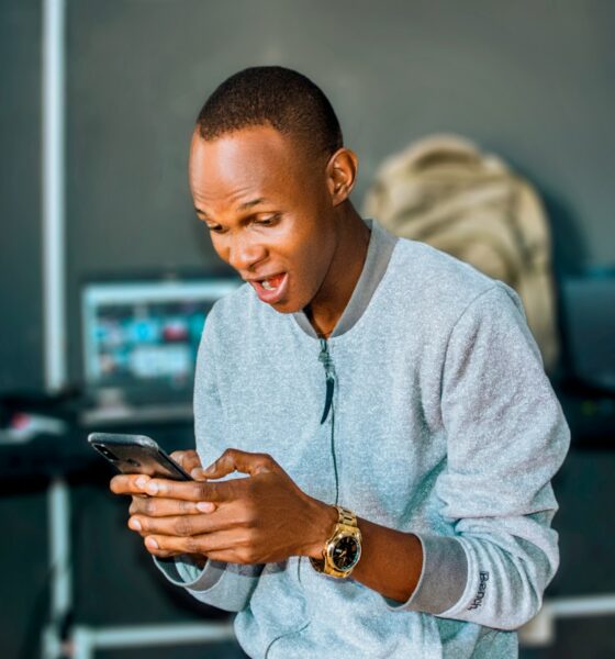 a man looking at his cell phone and laughing